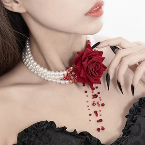 Detail of Gothic red fabric rose and white pearl multi-layer necklace on model neck