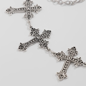 Macro detail of silver vintage cross body chain with intricate star relief patterns