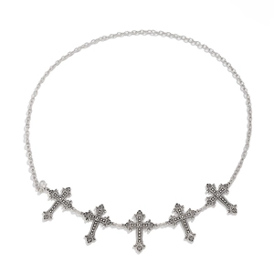 Detail of silver body chain featuring five embossed cross pendants with a lobster clasp