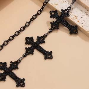 Macro detail of Gothic cross chain with baroque carvings and star pattern on matte metal