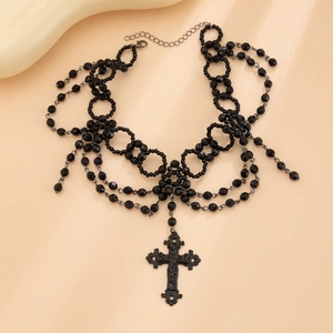 Detail van gotische zwarte kralenketting met meerdere lagen en een grote kruishanger met sluiting