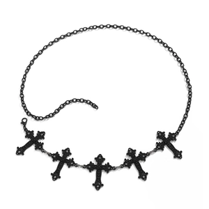 Close-up of black gothic cross pendants on a layered waist body chain for Halloween