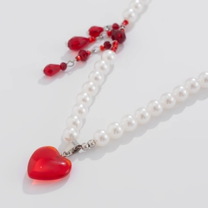 Detailed view of blood drip heart pendant and white pearl choker for Halloween