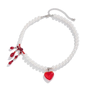 Detailed view of multilayer pearl necklace with red heart pendant and crystal drip tassels
