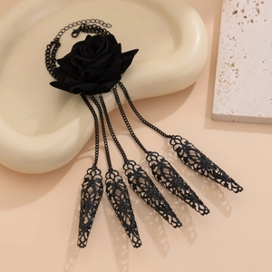 Macro shot of gothic black rose necklace with layered chain tassels and metal pendants