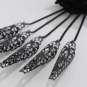 Detailed view of gothic hollow metal finger armor rings with black chains and roses
