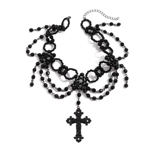 Gedetailleerde weergave van gelaagde zwarte gothic kralenketting met reliëf kruishanger