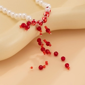 Macro shot of tiered pearl necklace with red crystal beads and dripping fringe detail