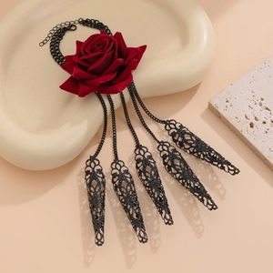 Close-up of gothic velvet red rose necklace with black metal tassels and hollow charms