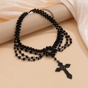 Detail van gotische zwarte kralenketting met een vintage kruishanger erop