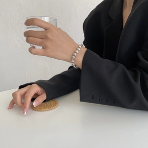 Nahaufnahme des minimalistischen silbernen Herzarmbands, getragen von einem Modell