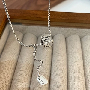 Dettaglio del pendente quadrato in argento con incisione Good Luck e piastrina Lucky