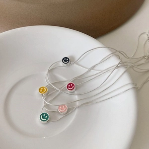 Colliers avec pendentif smiley en émail arc-en-ciel et chaînes serpent sur plat céramique