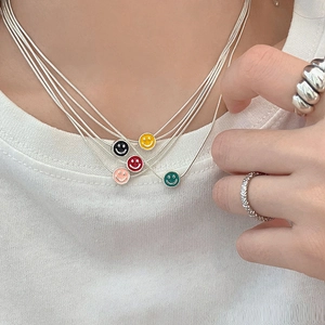 Collier argenté multicouche avec pendentifs sourires émaillés et bague texturée