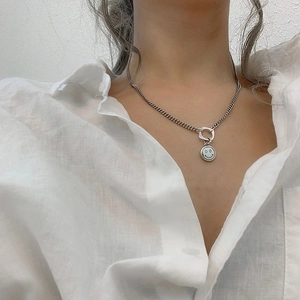 Collier rétro argenté avec pendentif smiley sur chaîne cubaine porté sur une chemise