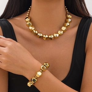 Primer plano del conjunto de collar y pulsera con grandes cuentas doradas
