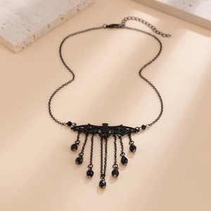 Detailed macro shot of Gothic black bat pendant with tassel chains and crystals