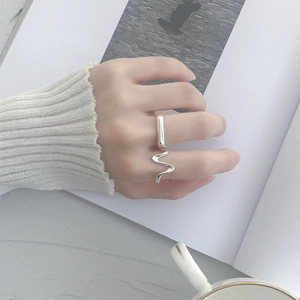 Bague ouverte en argent au design ondulé épuré, portée avec un style lifestyle