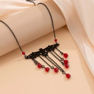 Close-up of gothic black bat necklace with hanging red crystal beads and fringe chains