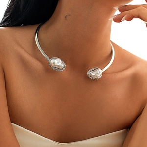 Détail d'un collier choker argenté orné de deux grandes perles baroques au design ouvert
