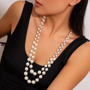 Detail of elegant double-layered pearl necklace with silver chain on model for women