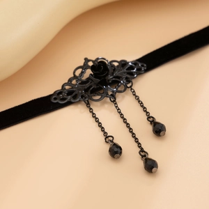 Macro shot of gothic black velvet choker with metal rose and tassel beads details