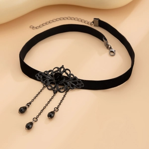 Macro view of gothic black velvet choker with metal rose pendant and tassel beads