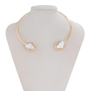 Détail du collier choker doré rigide avec perles baroques et finition métallique lisse