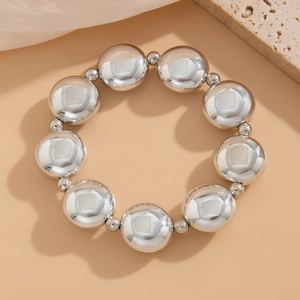 Primer plano de grandes cuentas metálicas plateadas en una elegante pulsera geométrica