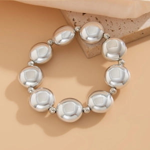 Détail macro de grandes perles argentées métalliques avec finition miroir sur un bracelet