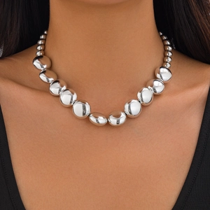 Detalle de collar de cuentas metálicas de alto brillo con reflejos en grandes cuentas de plata