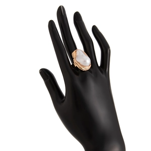 Détail d'une perle baroque sur un anneau doré ondulé porté par un mannequin main