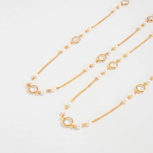Close-up of gold chain necklace with alternating faux pearls and round crystal beads
