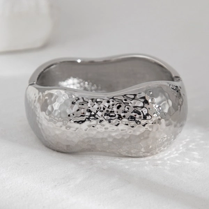 Detail of silver liquid metal bracelet featuring a hammered texture and irregular wave edge