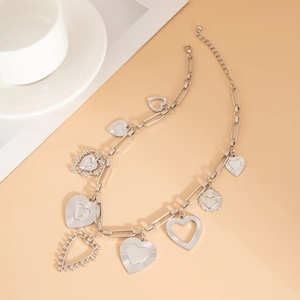 Detail of silver heart pendant necklace with chunky links and various heart charms