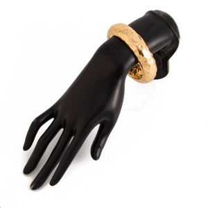 Detailed view of wide gold liquid metal cuff bracelet with hammered texture on hand