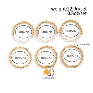Detailansicht eines 6-teiligen goldenen Perlenarmband-Sets mit HAPPY FALL-Buchstaben und Ahornblatt