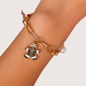 Dettaglio del ciondolo omino di pan di zenzero e perla su bracciale a catena dorata