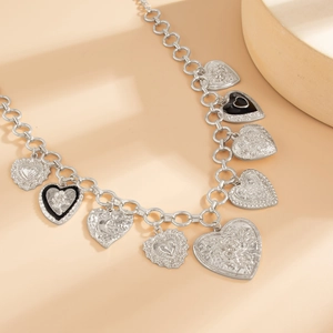 Detail showing vintage multi-heart metal pendants with floral relief and enamel textures