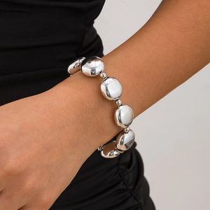 Pulsera de cuentas de metal plateado pulido con grandes esferas en la muñeca