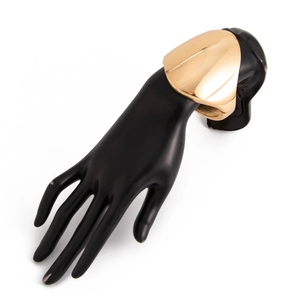 Close-up of a wide polished gold irregular metal spring cuff bracelet on a black hand model