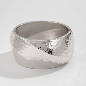 Detailed view of hammered wavy metal texture on silver wide cuff bracelet surface
