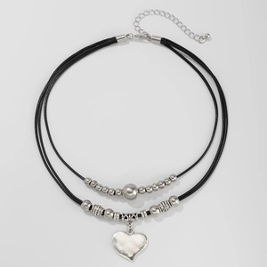 Detail view of double-layer vintage necklace with heart pendant and metallic beads