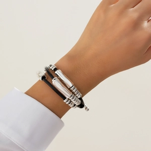 Detail of bohemian black leather wrap bracelet with silver tubes and beads on a wrist