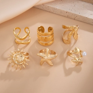 Detailansicht des 6-teiligen Goldringsatzes mit Seestern, Muschel, Perle und Sonnenmotiven