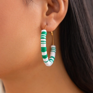 Close-up of polymer clay Christmas hoop earrings worn by a model in a side view