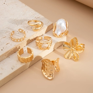 Detailansicht des 7-teiligen Goldring-Sets mit Barockperle und Blumendesign