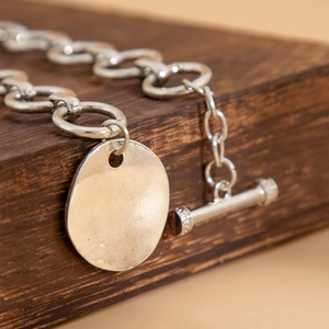 Dettaglio della collana a maglie d'argento con chiusura a T e ciondolo ovale liscio
