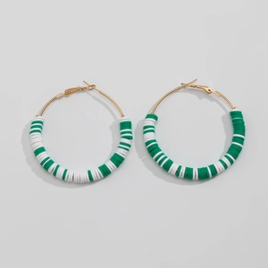 Detailed view of large gold hoop earrings with green and white striped heishi beads