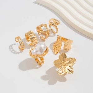 Nahaufnahme von 7-teiligem Goldring-Set mit unregelmäßiger Perle und Blumenmustern